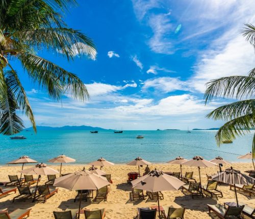 beautiful-tropical-beach-sea-ocean-with-coconut-palm-tree-umbrella-chair-blue-sky-min.jpg